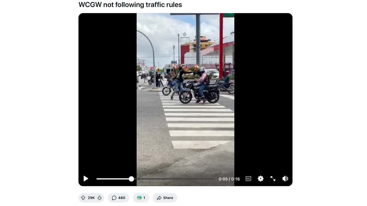 Motorcyclists obstruct intersection, crossing guard comically taps them on the head.
